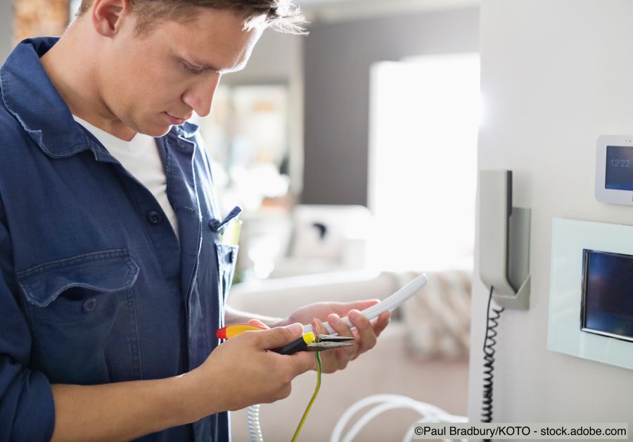 Elektriker bei Arbeiten am Telefon in der Wohnung
