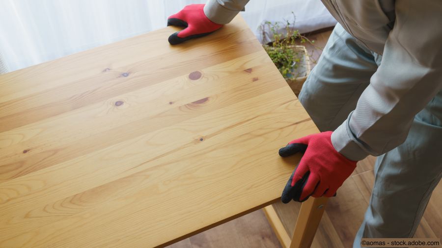 Fachmann transportiert einen Holztisch