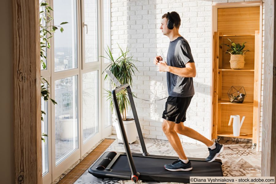 Junger Mann beim Joggen auf dem modernen Kompakt-Laufband zu Hause