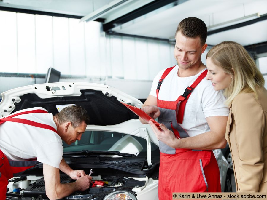 Kfz-Mechaniker und Kundin in der Autogarage