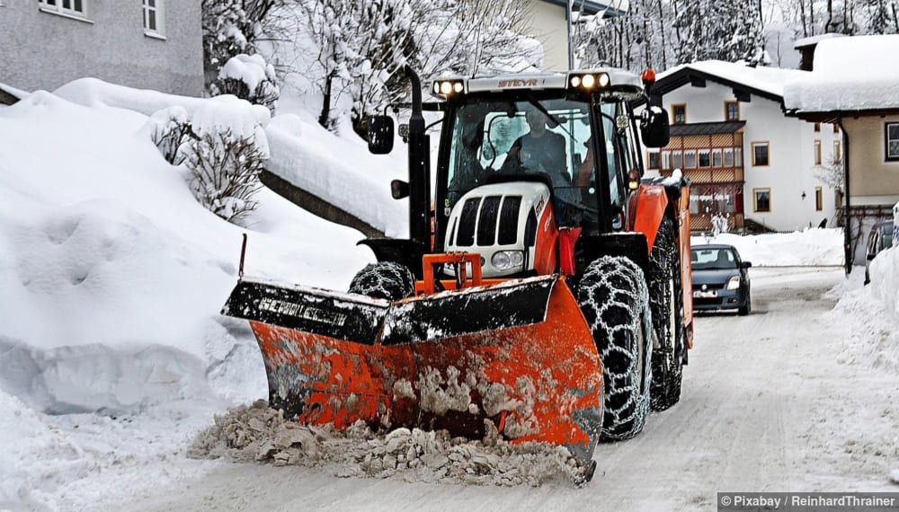 Winterdienst räumt Schnee von der Einfahrt eines Einfamilienhauses