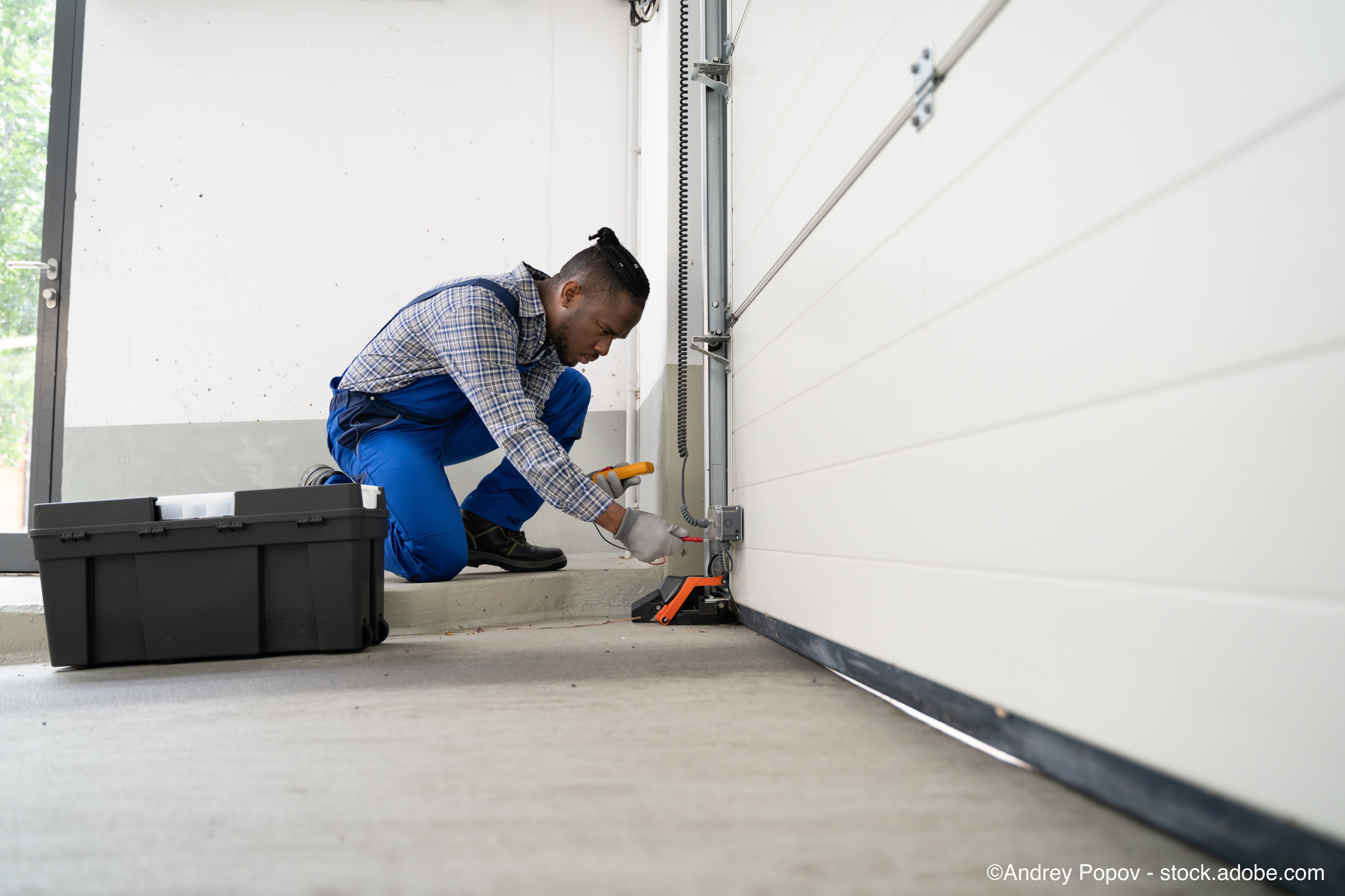 Handwerker bei der fachgerechten Montage eines Garagentors