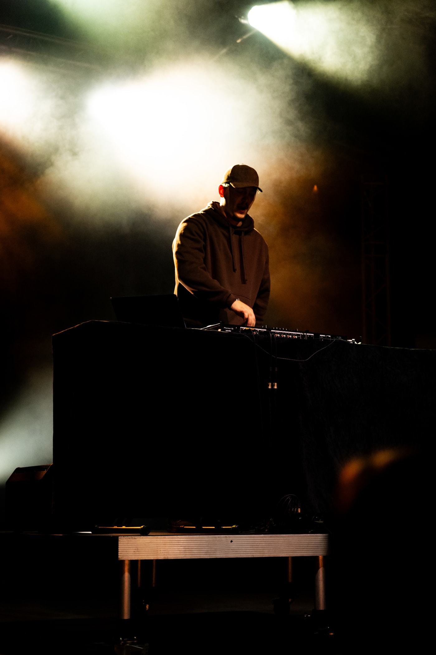 Silhouette d’un musicien sur scène, fumée et contre-jour doré