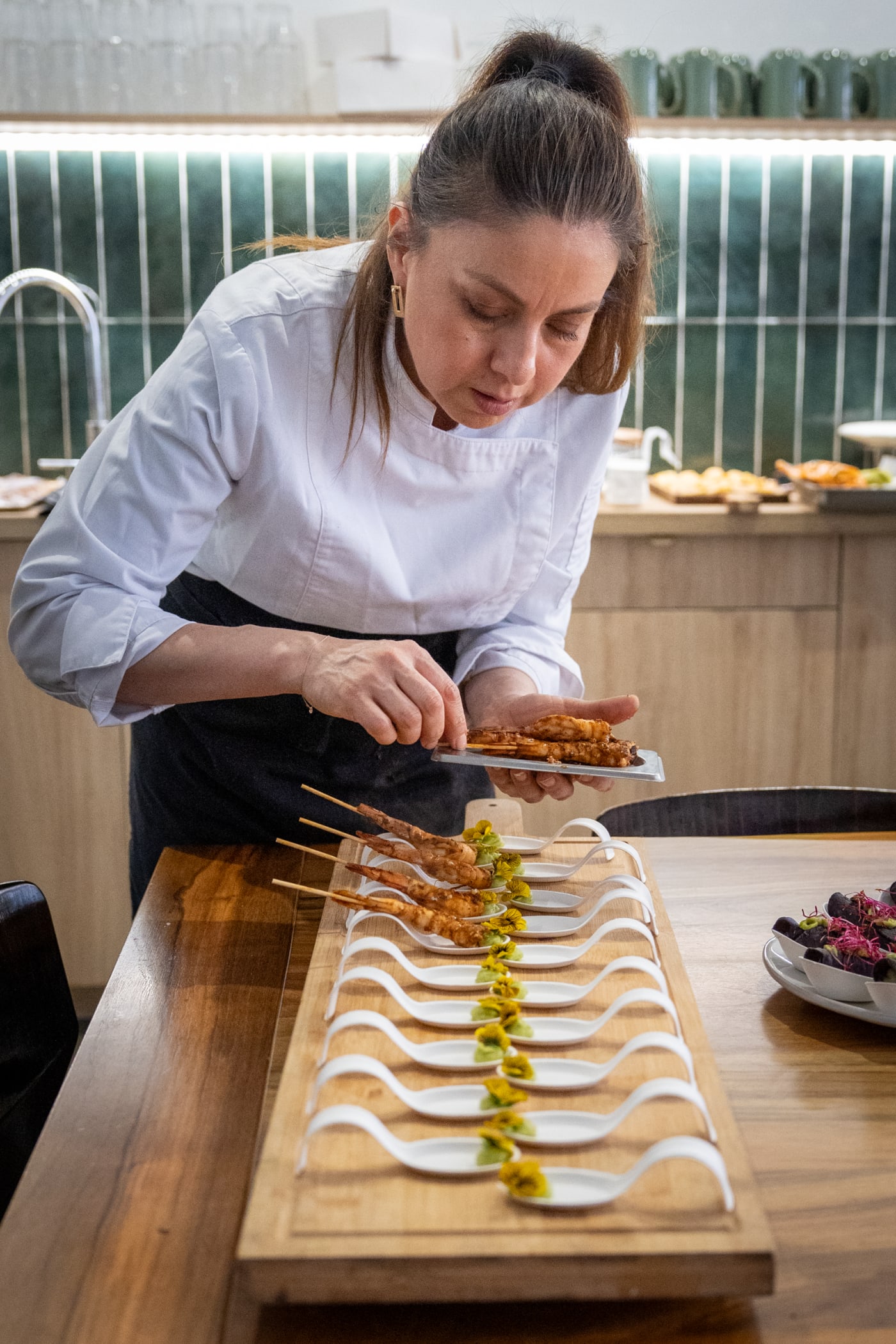 Cuisinière déposant des garnitures sur une planche de service