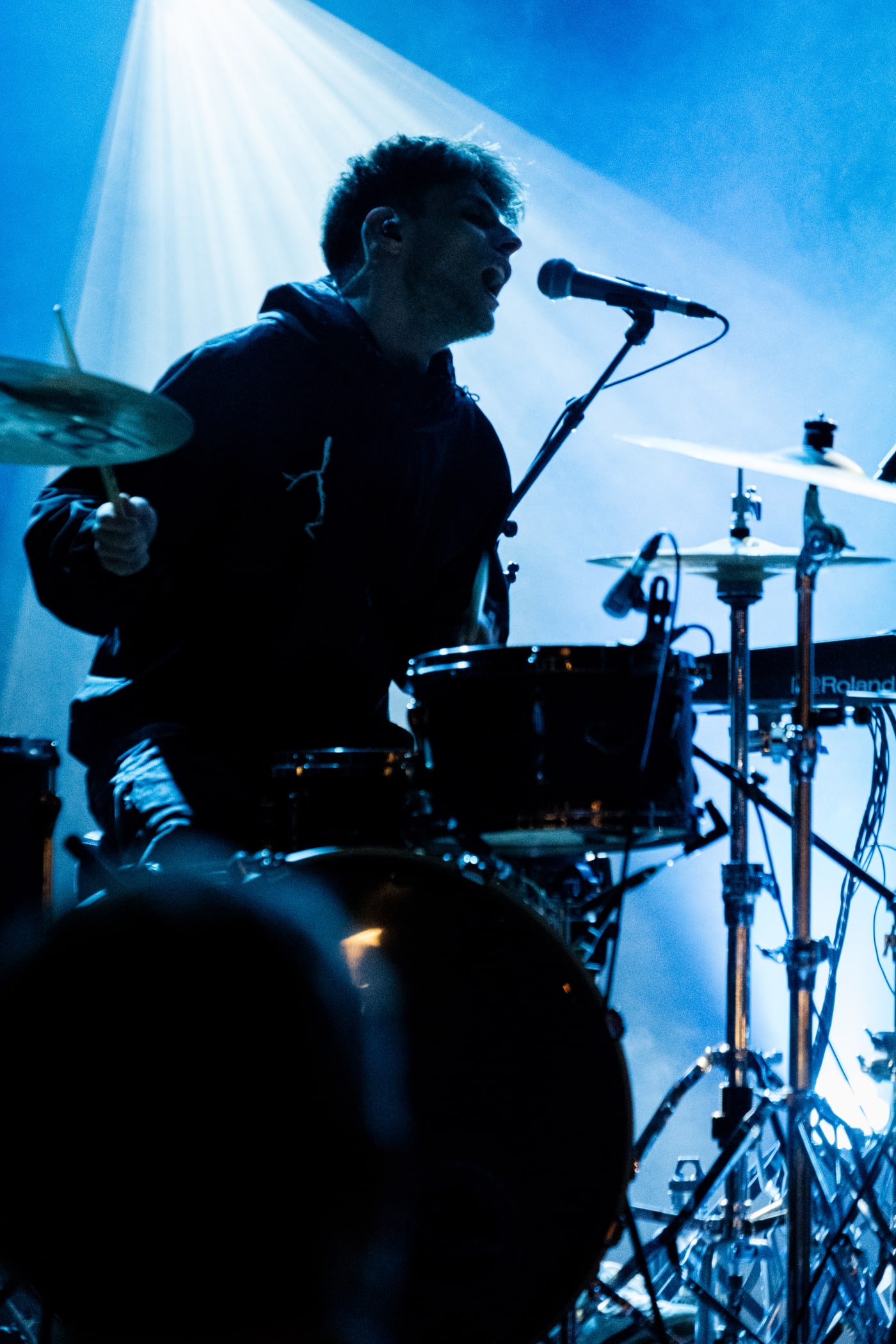 Batteur et musicien sur scène éclairés de bleu