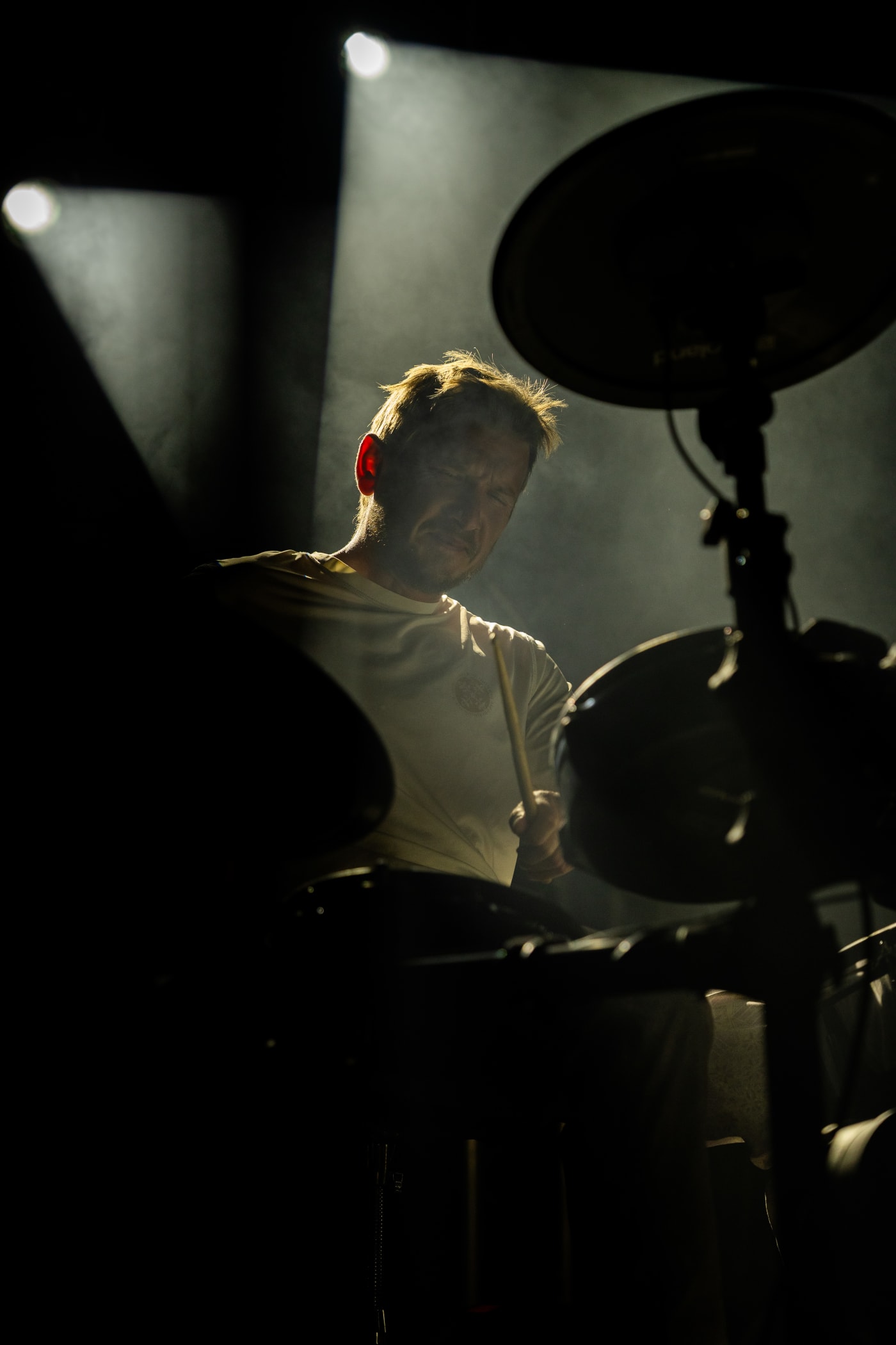 Silhouette d’un batteur à contre-jour derrière sa batterie