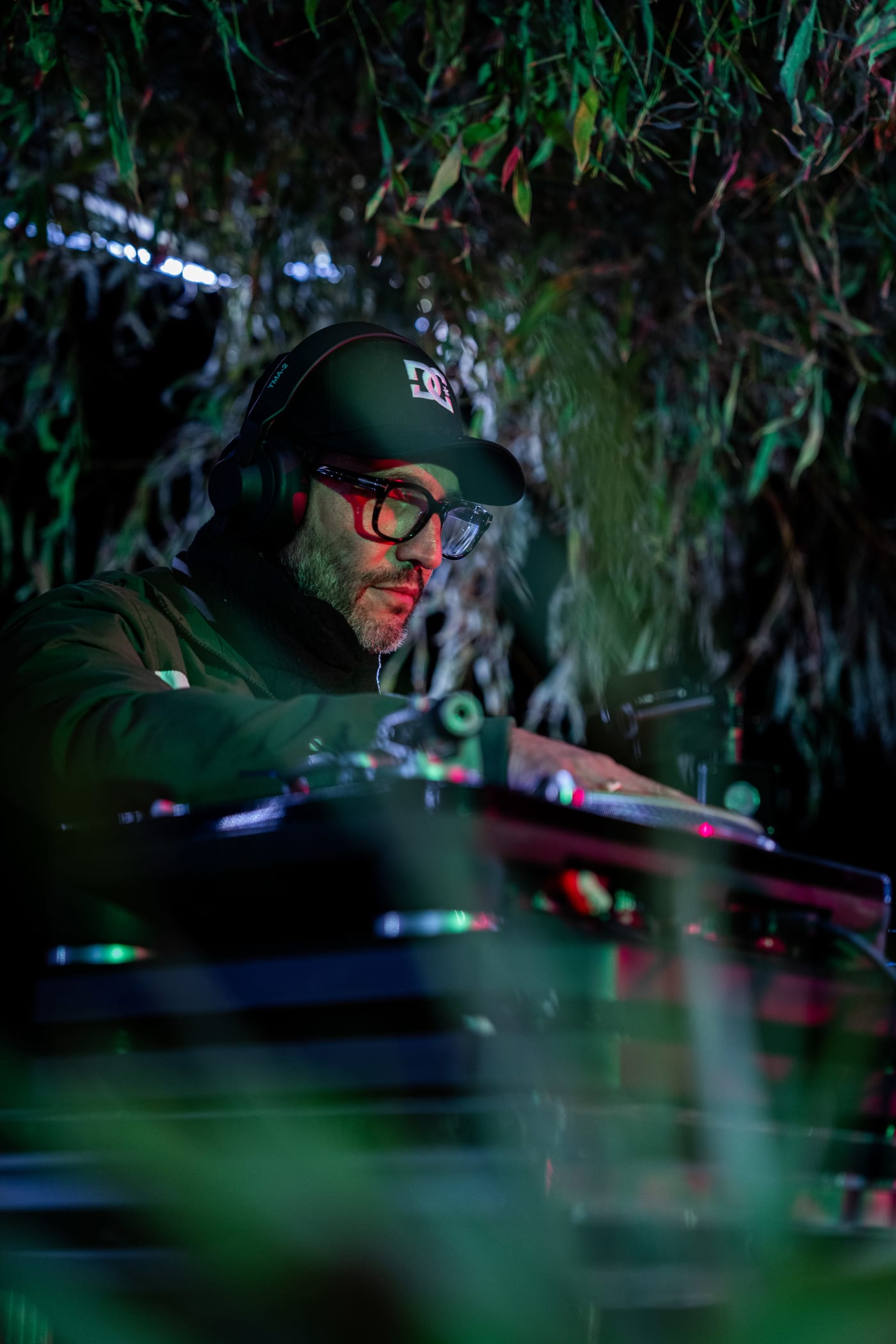 Musicien dans la végétation, éclairé de vert, au Belette Festival