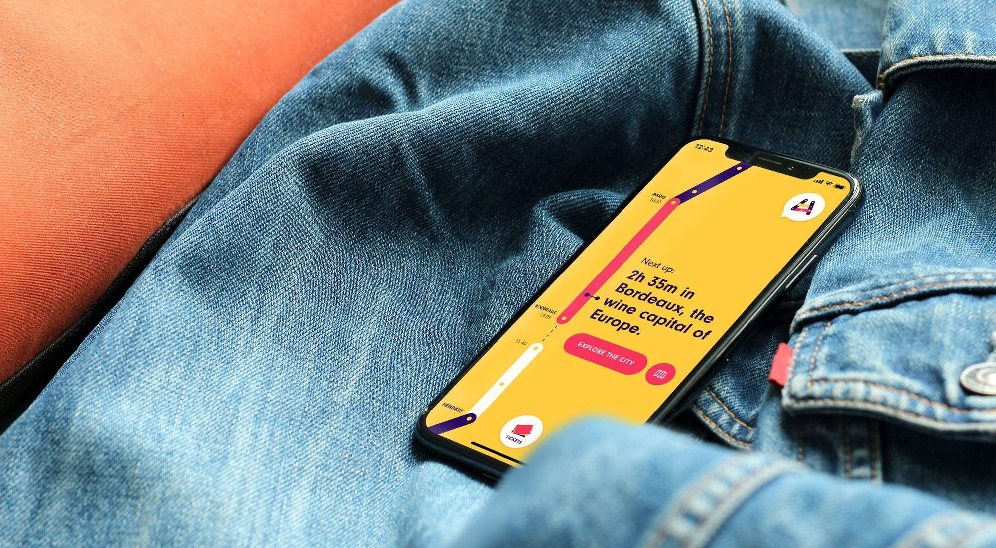 En smartphone som ligger på en jeansjacka med en All Aboard appen öppen