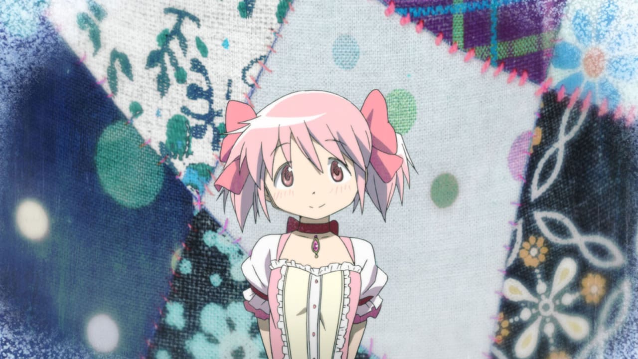 Madoka Kaname sorri com seus laços cor de rosa diante de um fundo de retalhos de tecido costurados