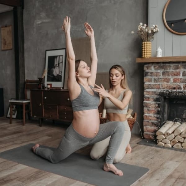 entrenadora y mujer embarazada realizando ejercicios