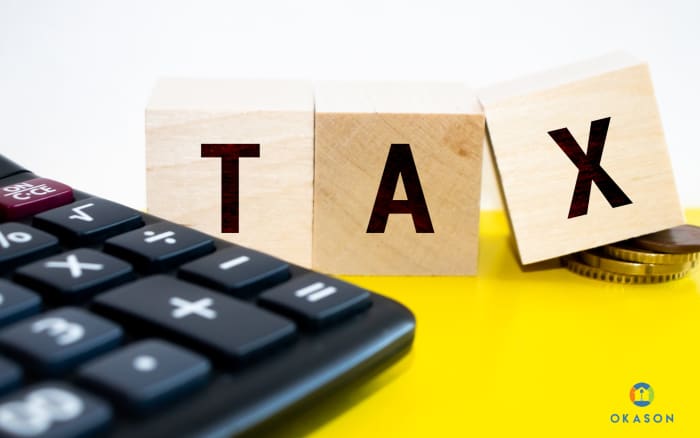 Landscaping business owner reviewing tax deductions on a tablet while sitting on a work truck tailgate with equipment visible in the background