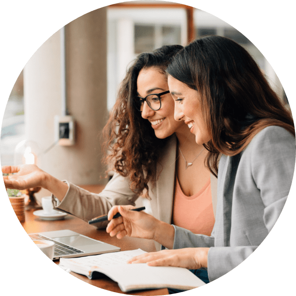 image of two women discussing something and smiling at a computer screen