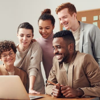 Group of young professionals looking at a laptop