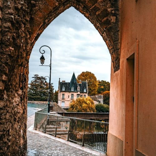 Perspective sous l'arc brisé vers le manoir et le Loing