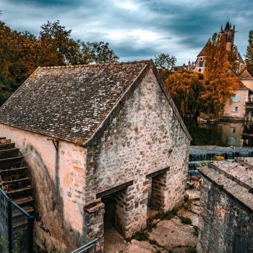 Roue du moulin et clocher dans les feuillages roussis