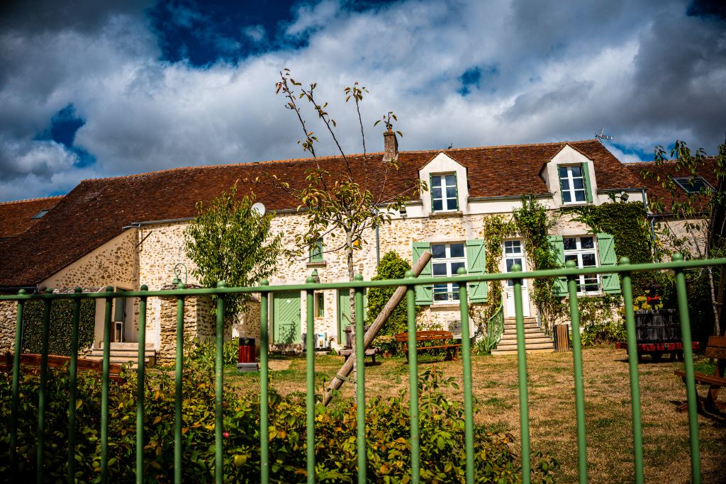 Façade en pierre du Domaine Bois Brillant et volets vert clair