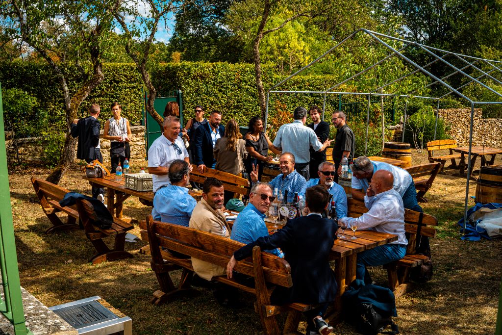 Participants installés autour des grandes tables en bois