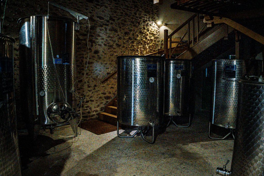 Cuverie moderne avec cuves en acier inoxydable et mur de pierre