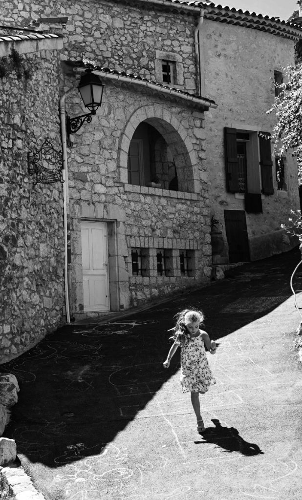 Enfant courant dans une ruelle médiévale pavée
