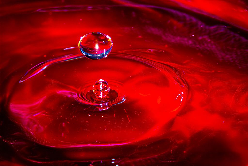 Macro d’une collision de gouttes d’eau rouge