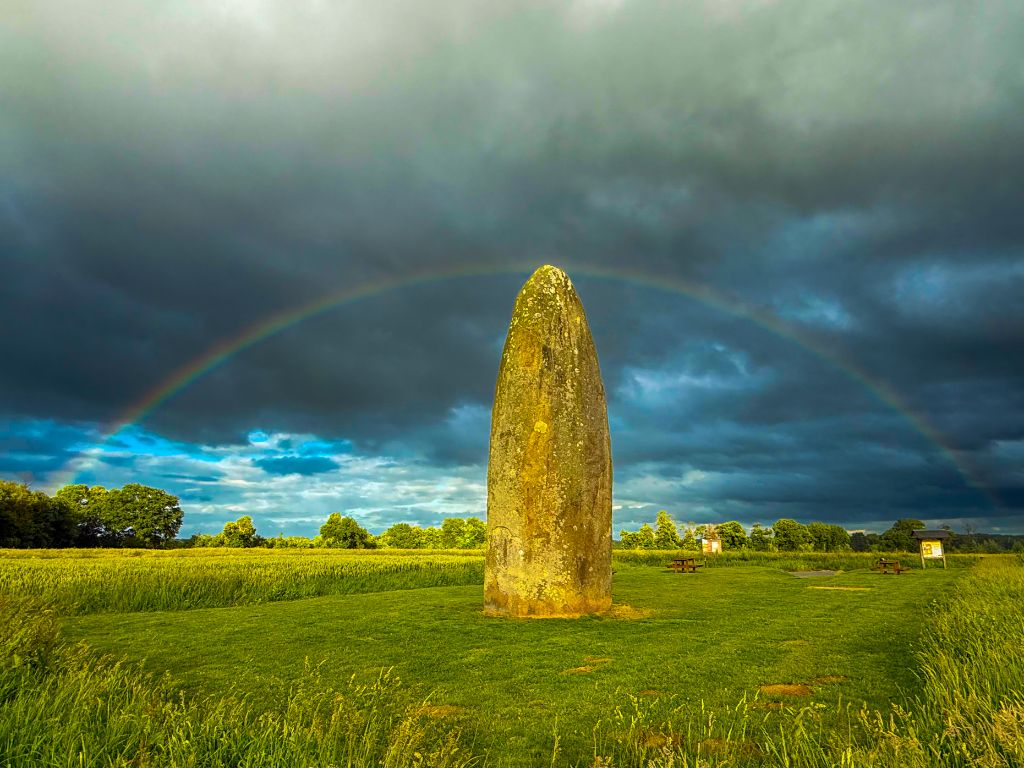 Menhir millénaire sous un double arc-en-ciel