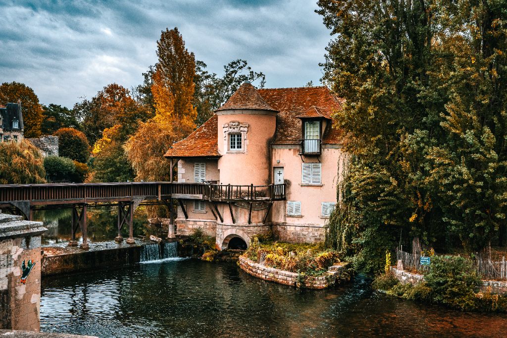 Le moulin, sa passerelle en bois et le déversoir bouillonnant sur le Loing