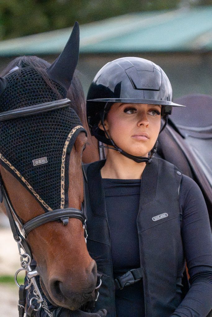 L’instant d’avant l’effort : cavalière et cheval bai au box