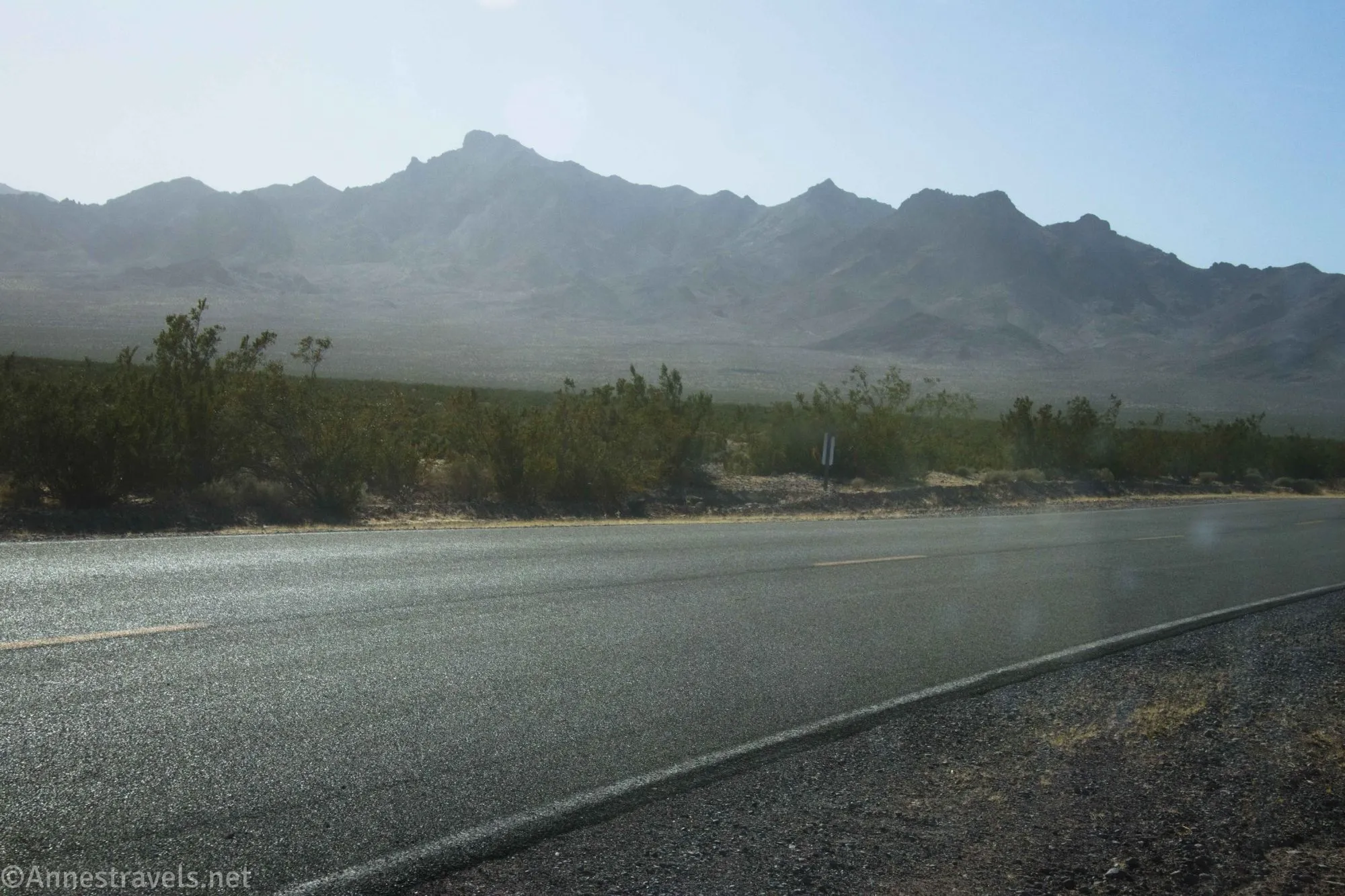 A paved road and hazy desert mountains