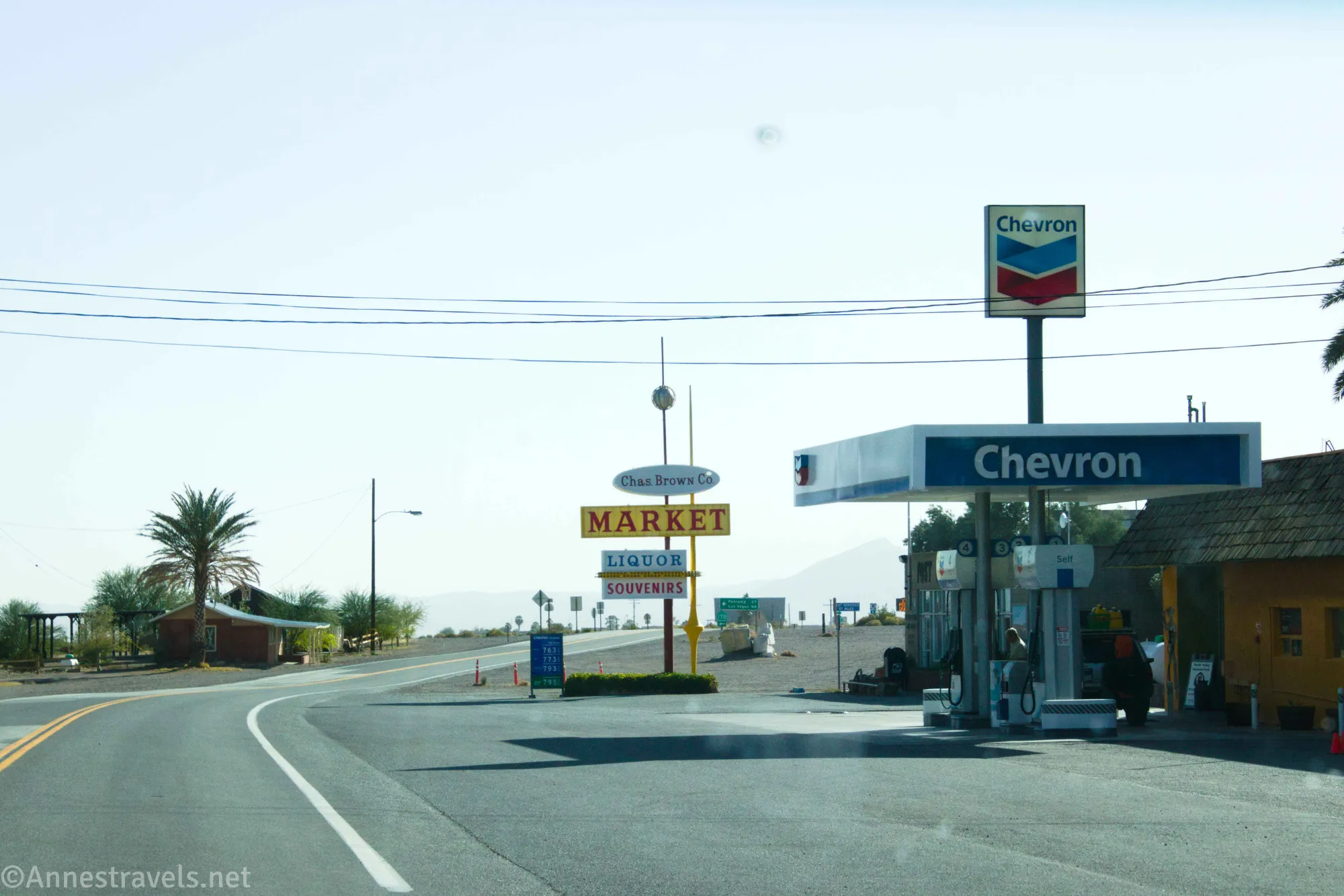 Chevron gas station with a market and a palm tree across the road