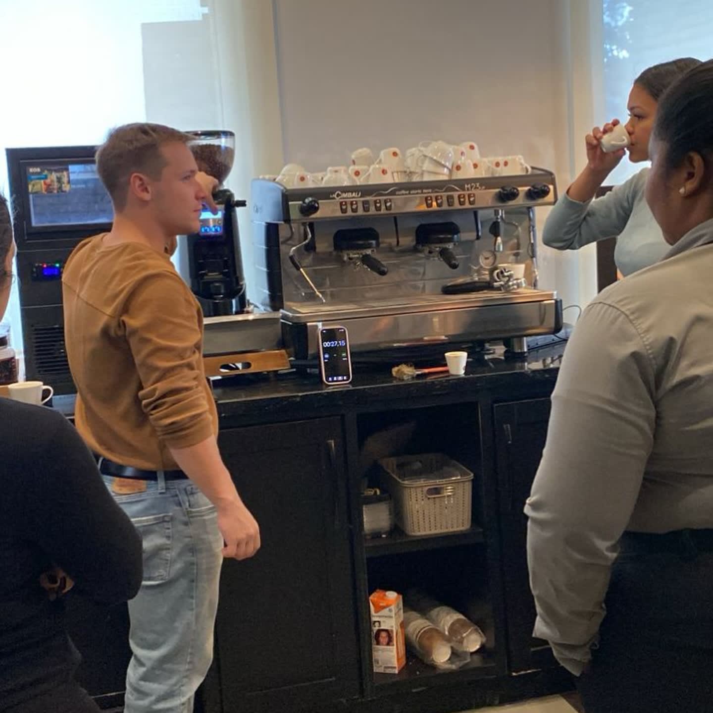 Matheus acompanhando a extração de espresso durante um treinamento de equipe