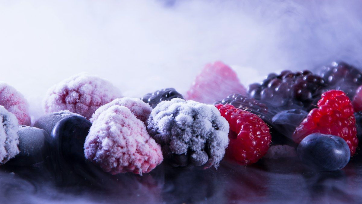 Fresh ingredients including frozen berries and thick yogurt ready for blending
