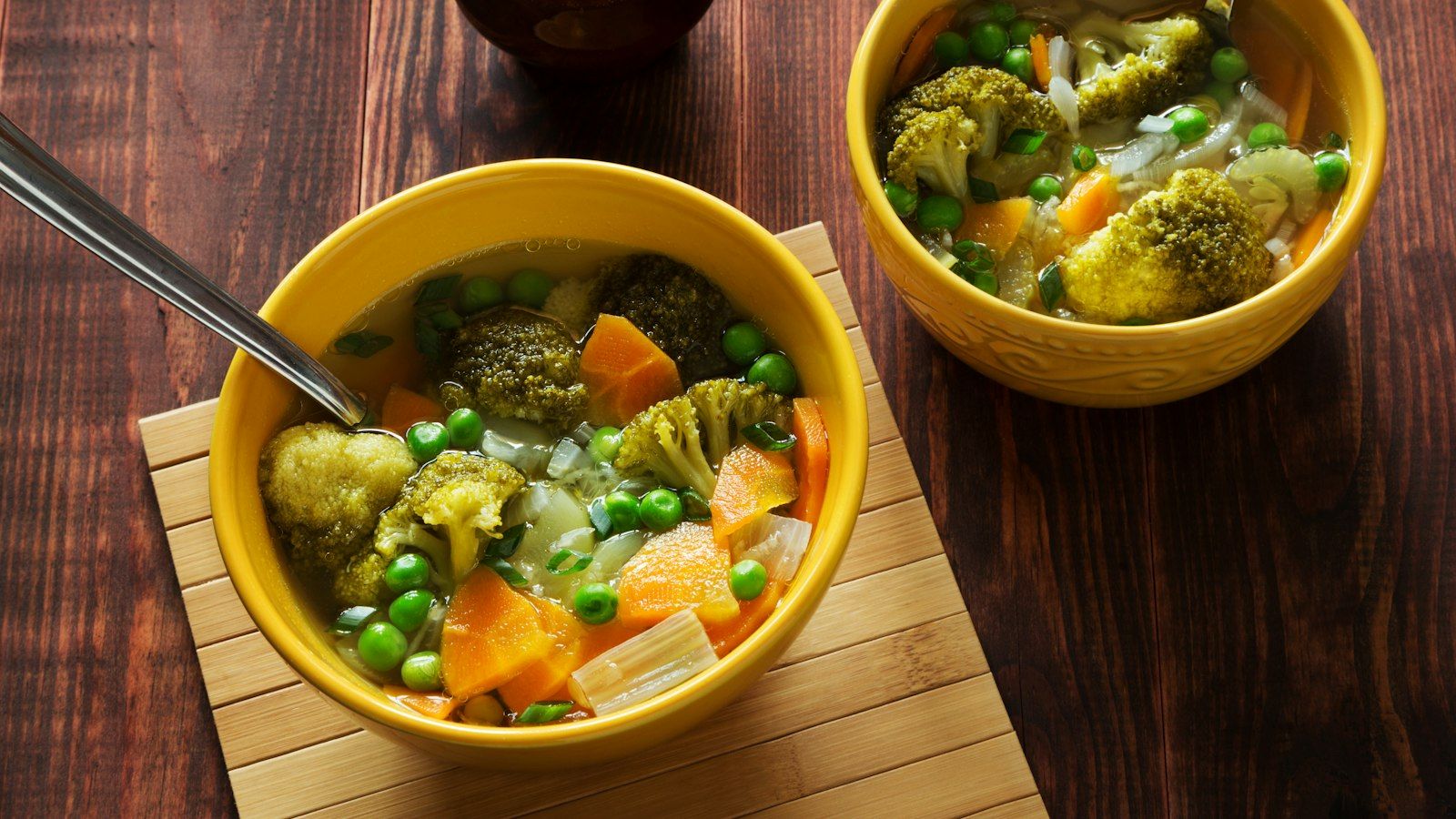 A steaming white bowl filled with colorful homemade cabbage soup and fresh chopped parsley
