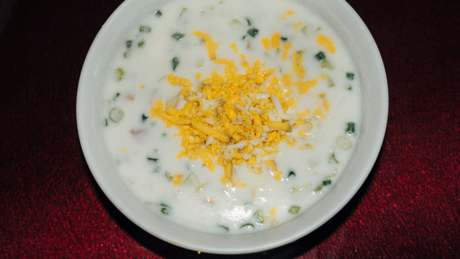 A bowl of easy crock pot loaded potato soup garnished with bacon and chives