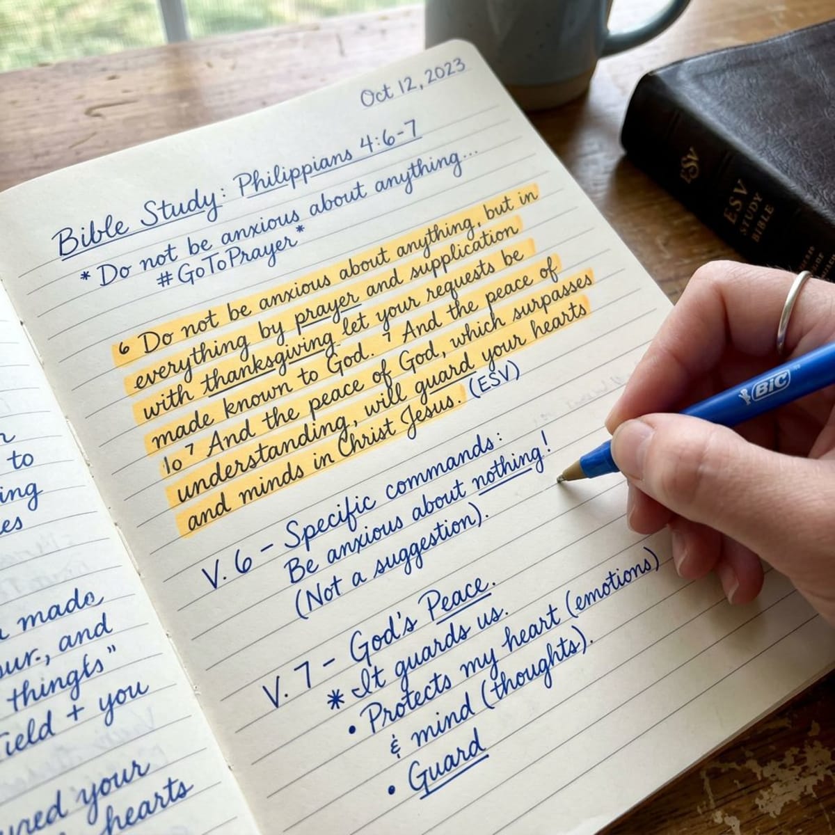 Close-up of handwritten notes in a Bible study notebook with highlighted verses and pen on paper