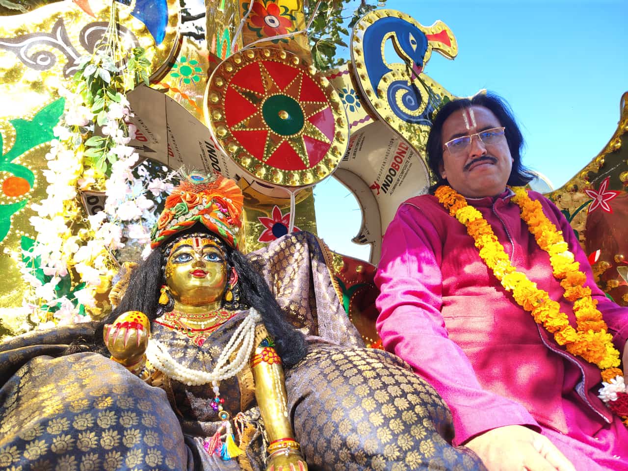 सजे हुए रथ यात्रा में देव प्रतिमा के साथ आचार्य जी