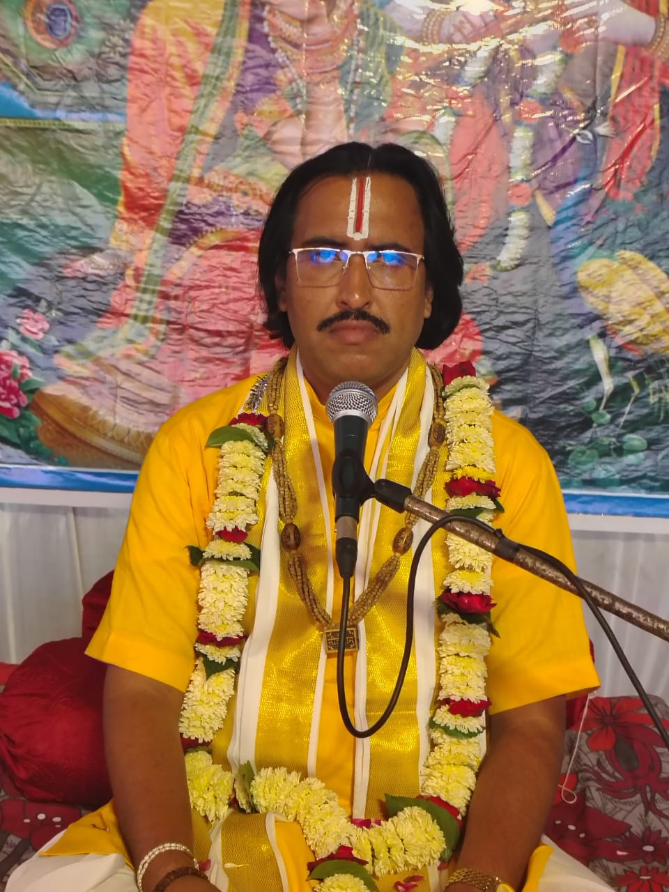 कथा के दौरान पुष्पमाला सहित विराजमान आचार्य जी