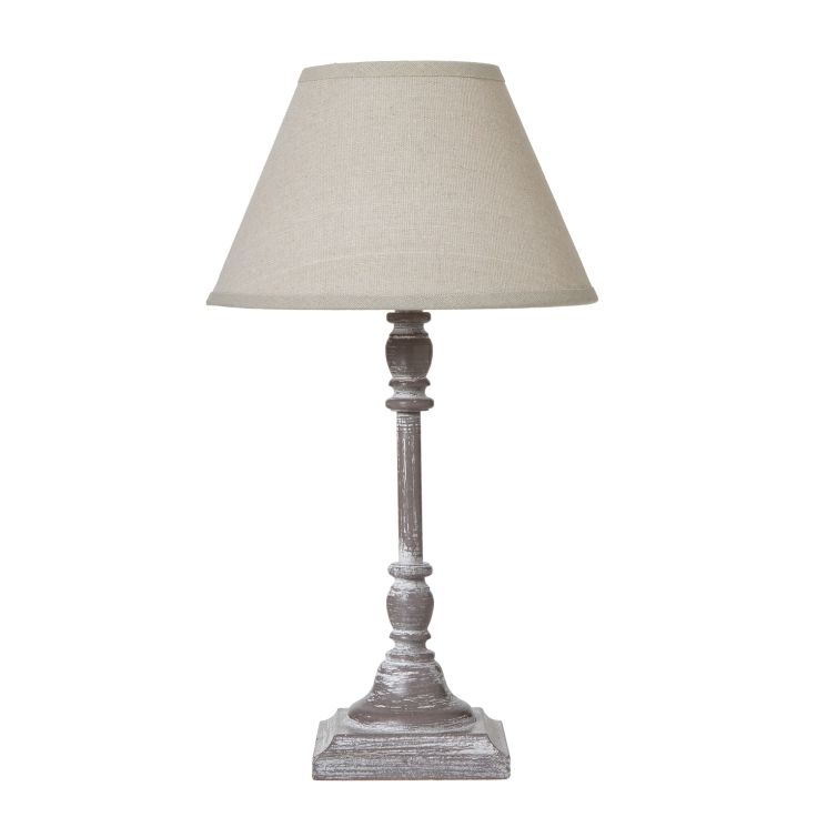 Antia Stem Table Lamp with a slender base and a warm natural linen shade on a wooden console table.