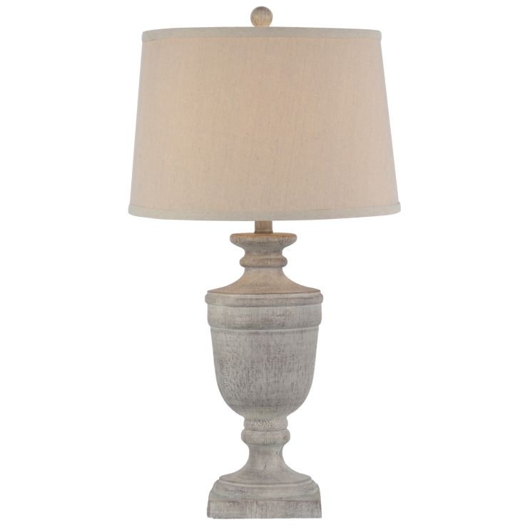 Ossia Table Lamp featuring a grey distressed stone urn base and a neutral linen drum shade on a wooden side table.