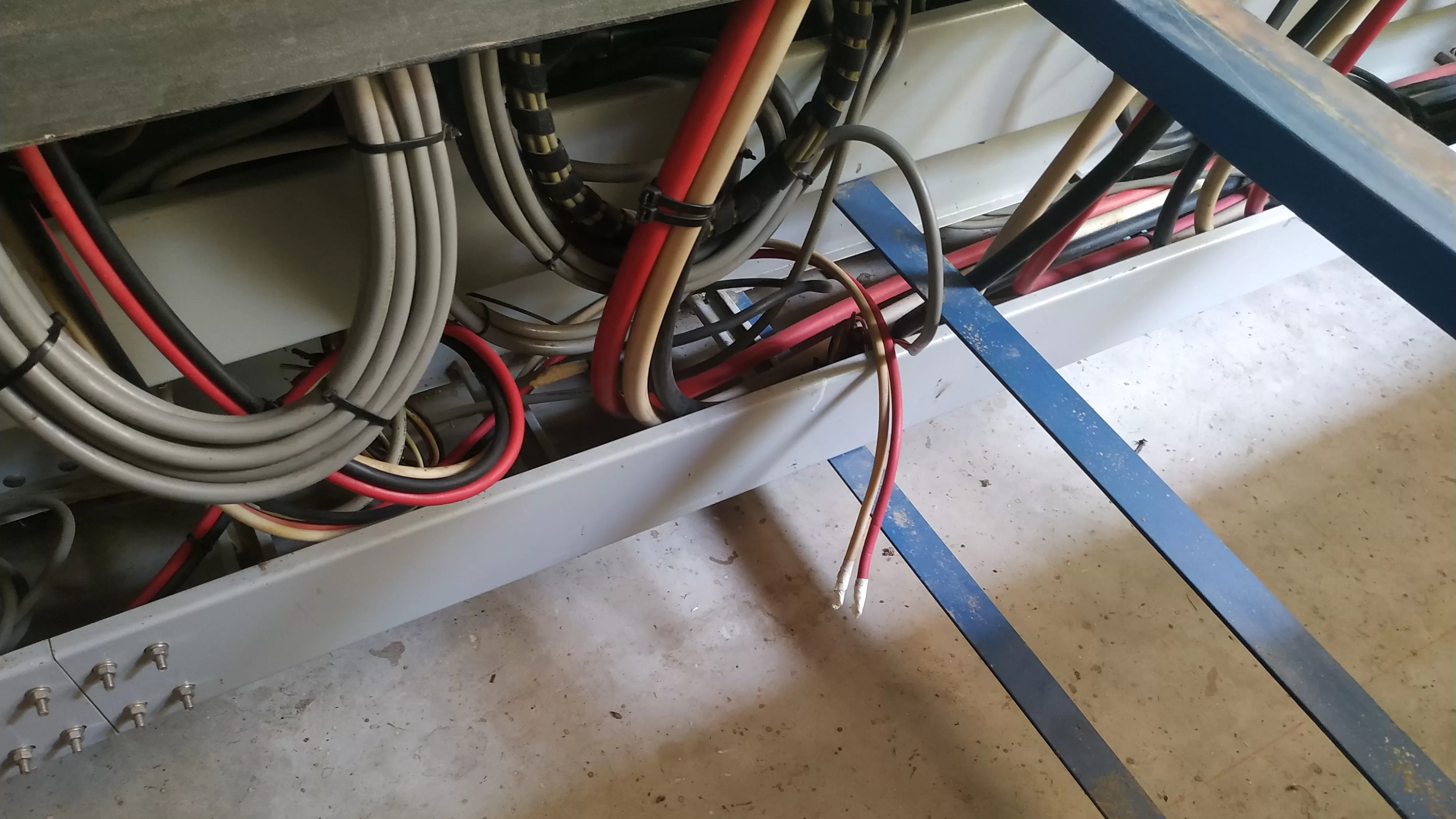 Conductores eléctricos deficientemente aislados dentro de zanja de conductores en subestación eléctrica