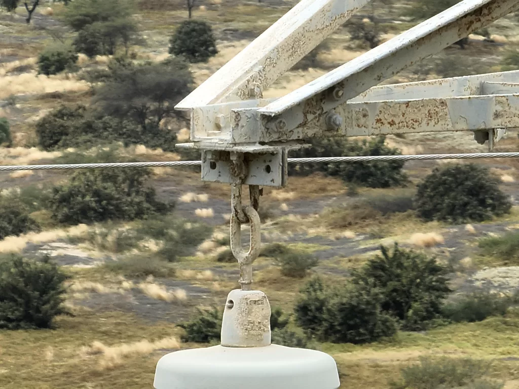 Fotografía de detalle de elementos de anclaje de aislador de línea en sistema eléctrico de transmisión