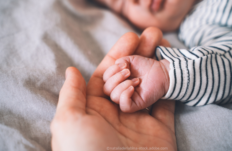 Baby sleeping with his hand in mothers hand