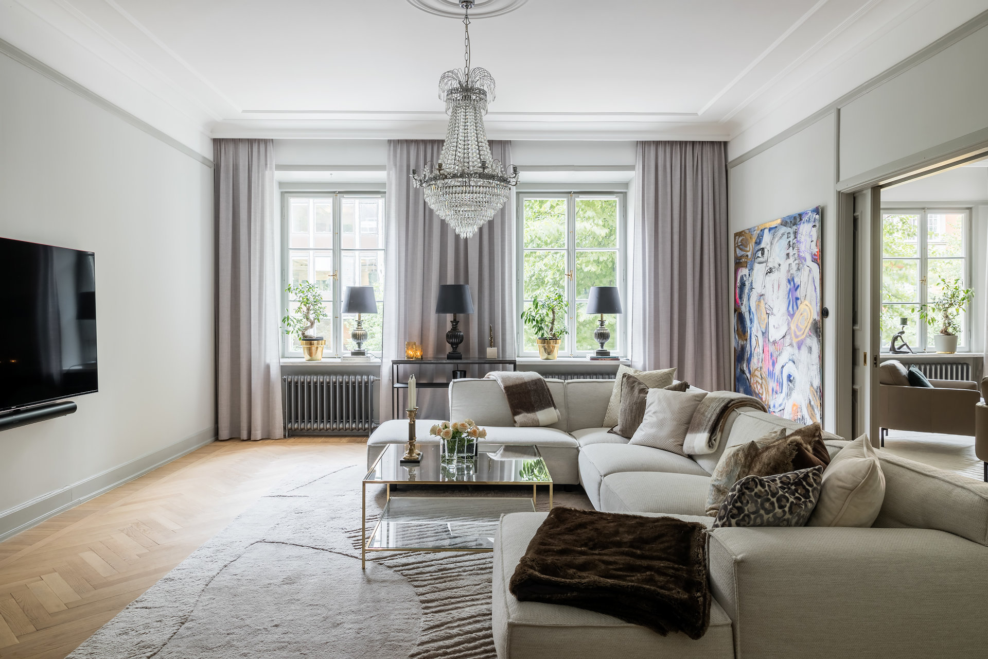 Charles Maison II living room with chandelier and high ceilings