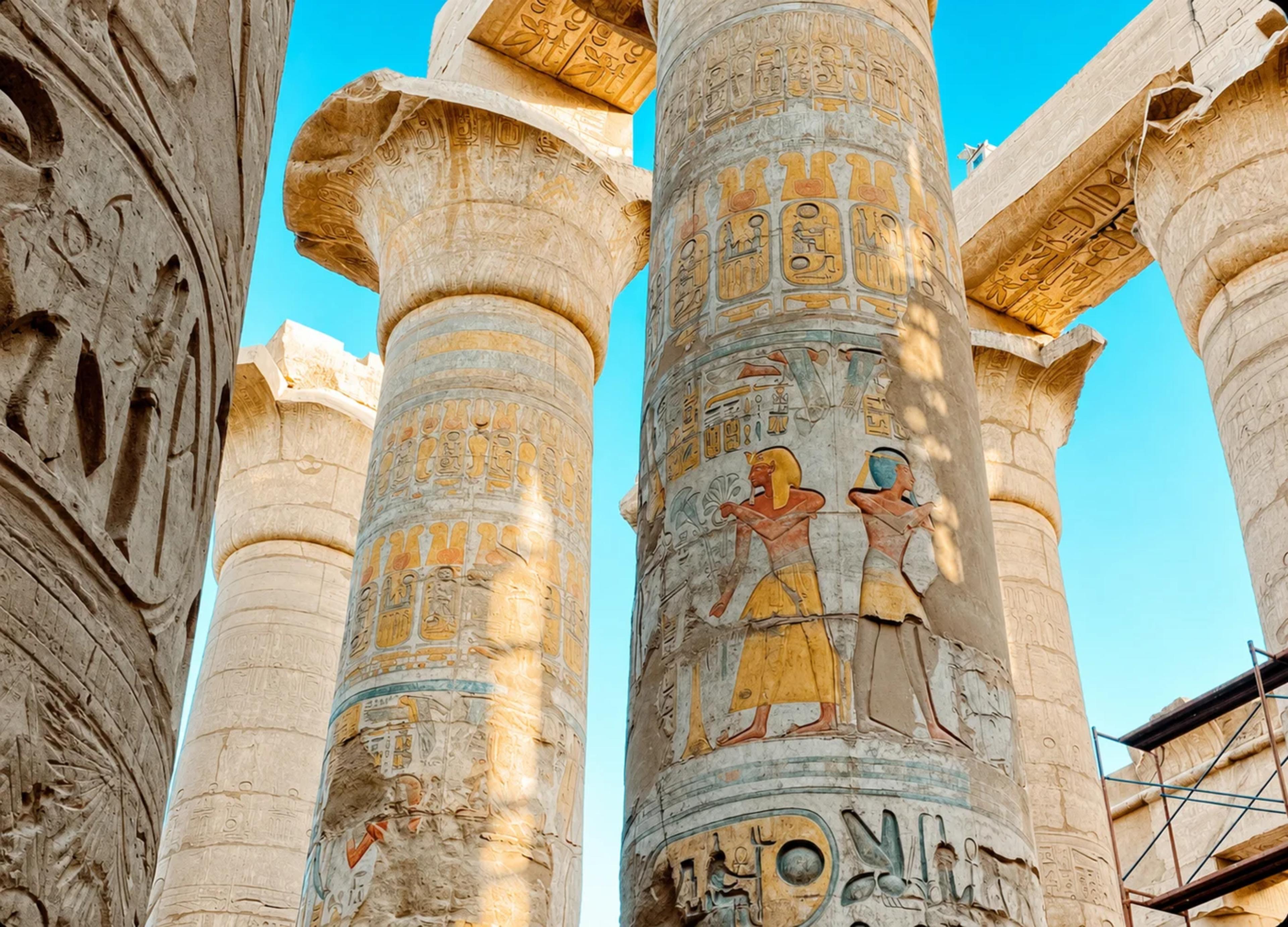 Column detail: the painted reliefs in the upper registers of the central columns retain original pigment. Red, blue, and ochre, 3,200 years old.