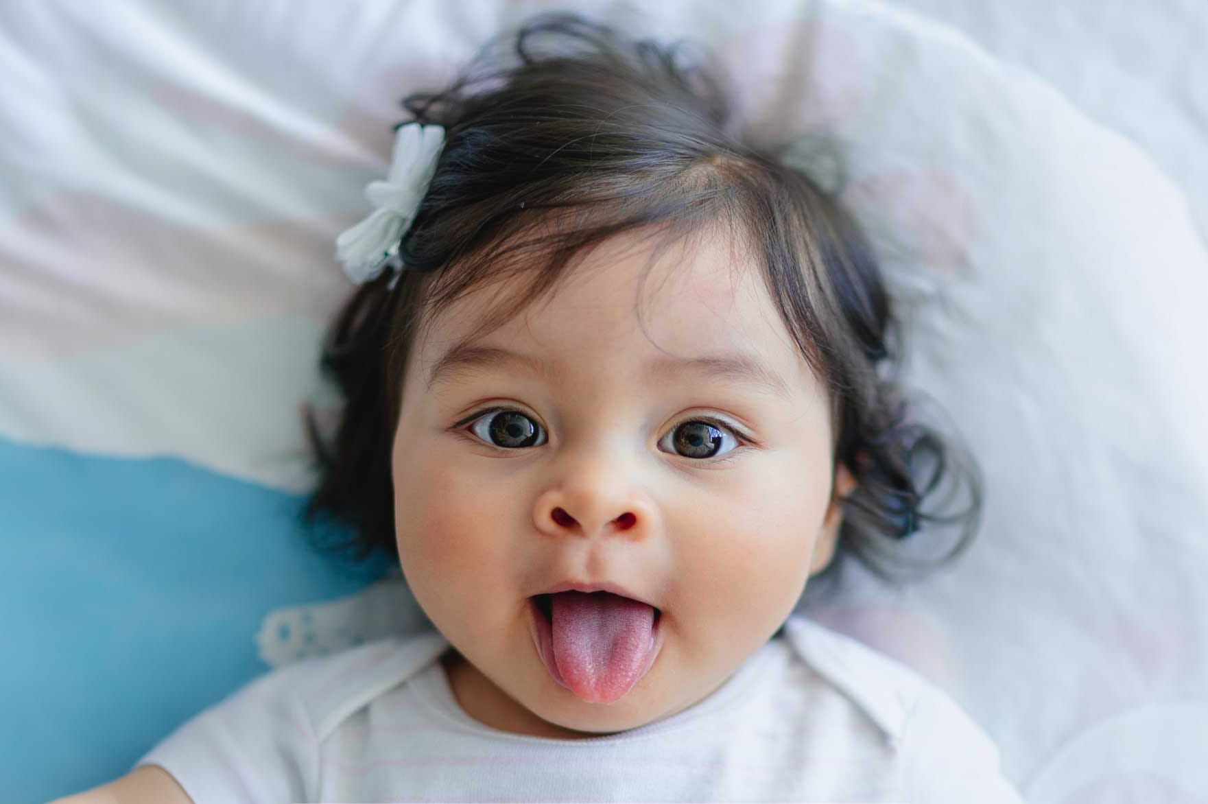 bebê abrindo a boca e mostrando a língua