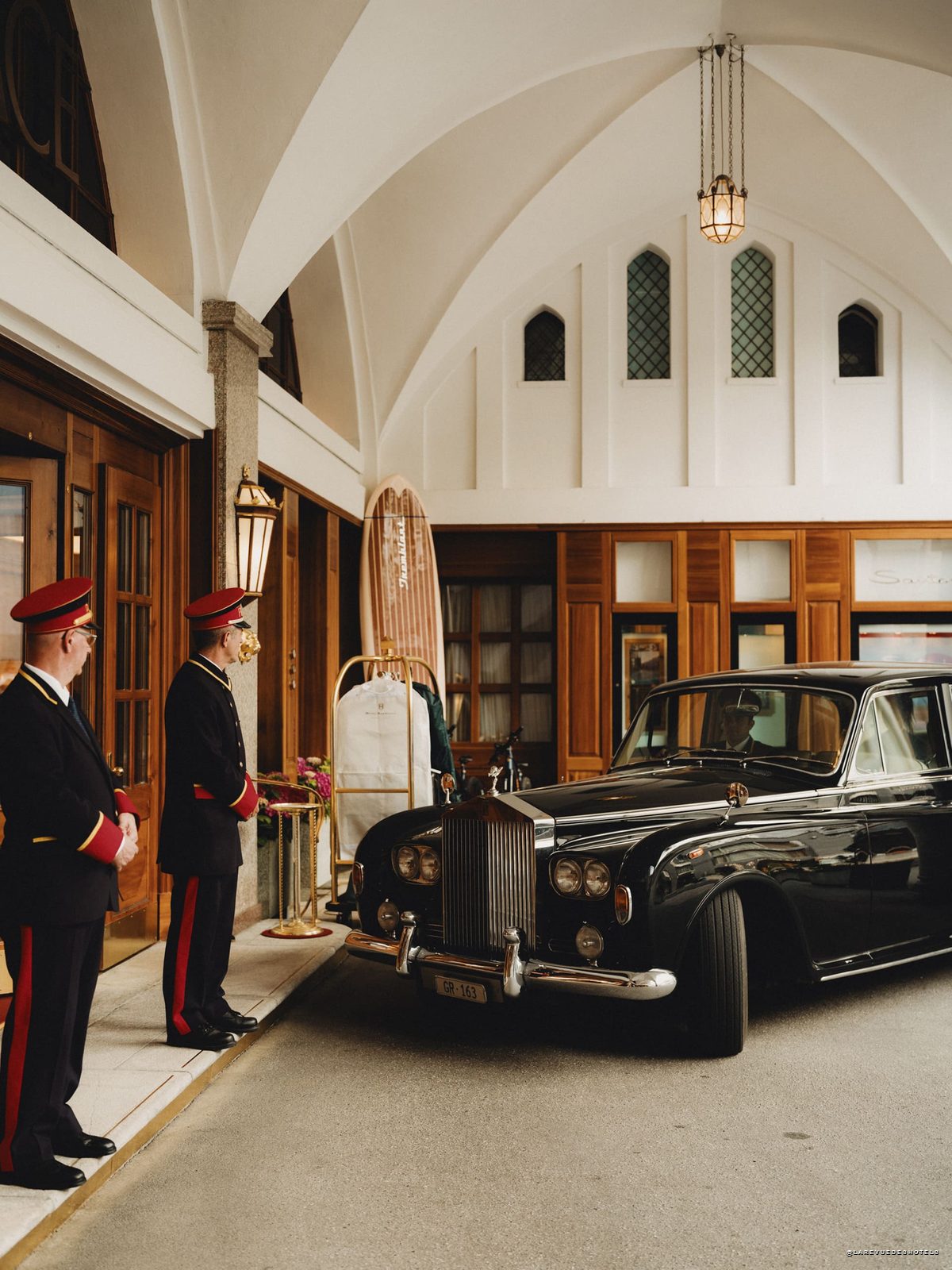 Voituriers en livrée et Rolls-Royce d'époque devant l'entrée du Badrutt's Palace à Saint-Moritz