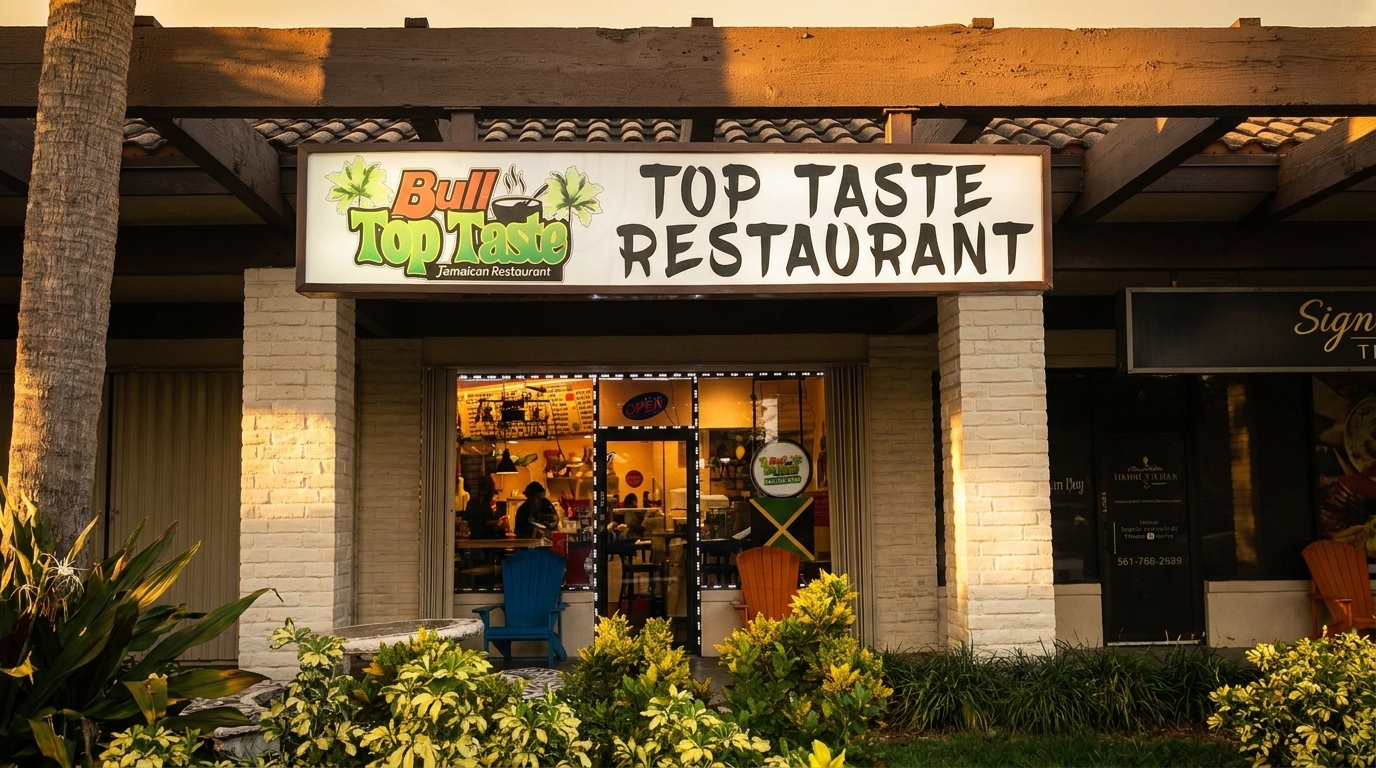 Exterior view of Bull Top Taste Jamaican Restaurant with its illuminated sign and storefront.