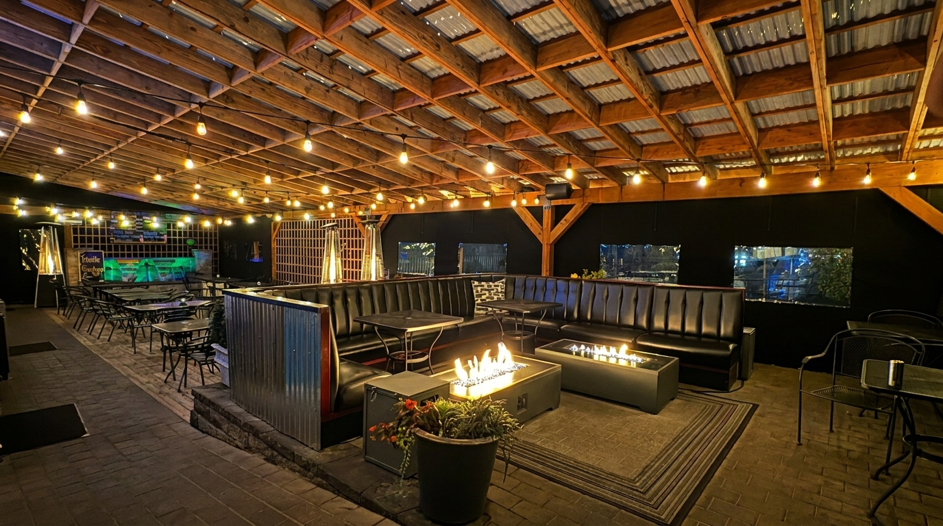 An inviting outdoor patio at night, featuring string lights, fire pits, and comfortable seating.