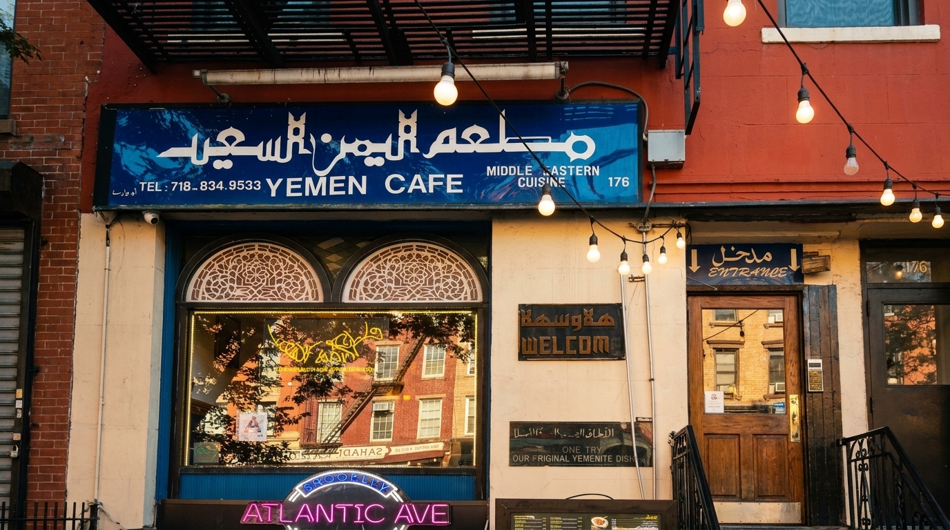 The exterior of Yemen Cafe, a Middle Eastern restaurant, with a blue sign and string lights.