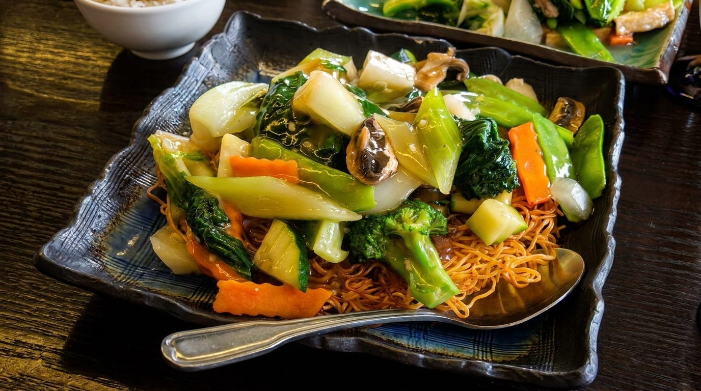Crispy noodles topped with vibrant stir-fried vegetables, including broccoli, carrots, and bok choy.