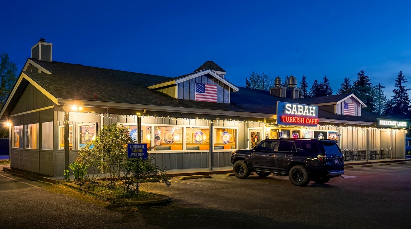 Exterior of Sabah Turkish Cafe at dusk, with illuminated signs, string lights, and a parked SUV.